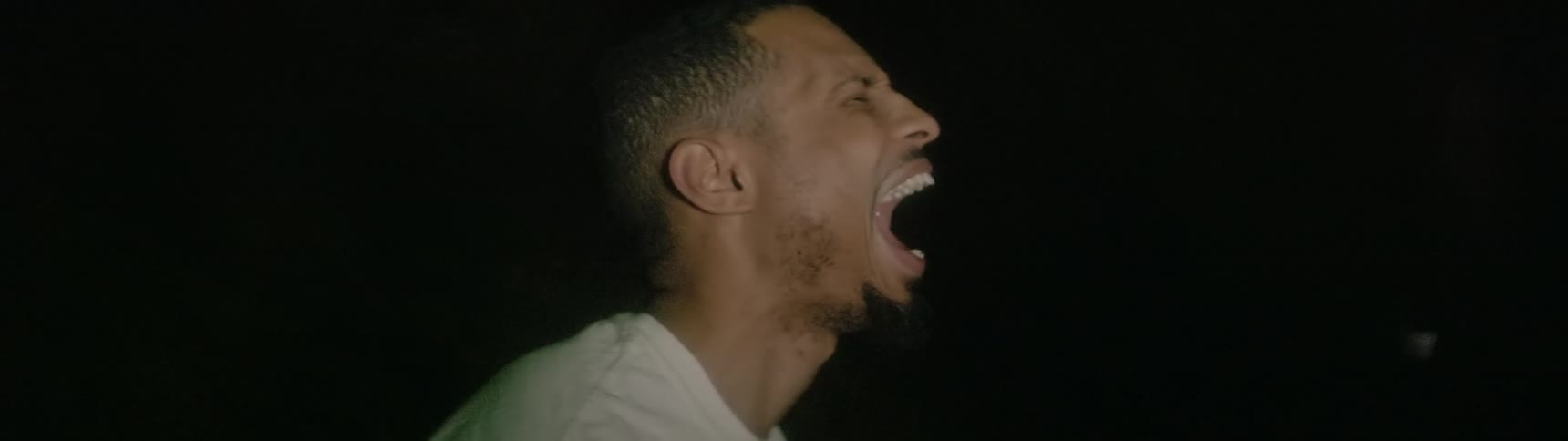 A man stands outside and yells