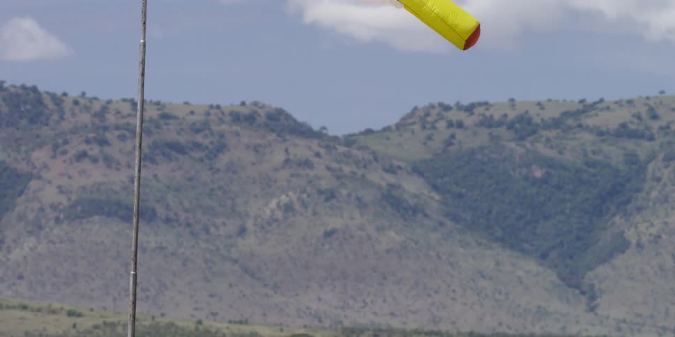 A windsock blows in the wind in a rural area