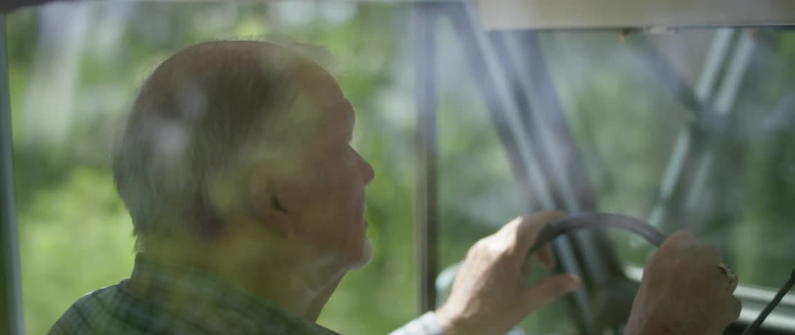 Elderly man drives a car in the countryside