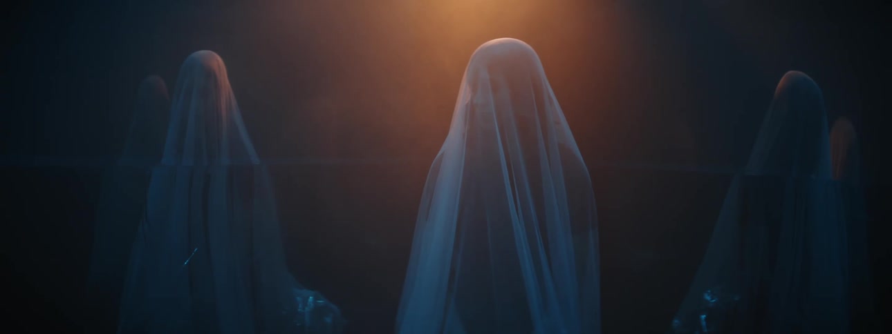 Four people stand indoors hidden by behind a plastic wrap