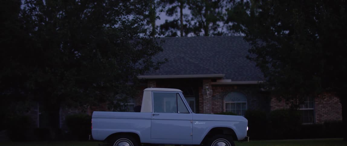 A truck drives and stops in front of a house