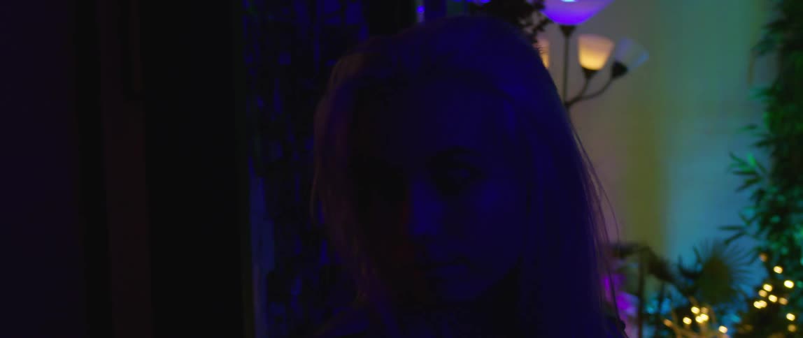 A teenager walks through a dark room