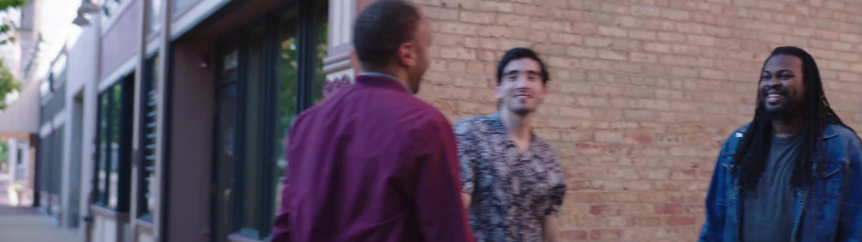 A group of men hug outside a town building