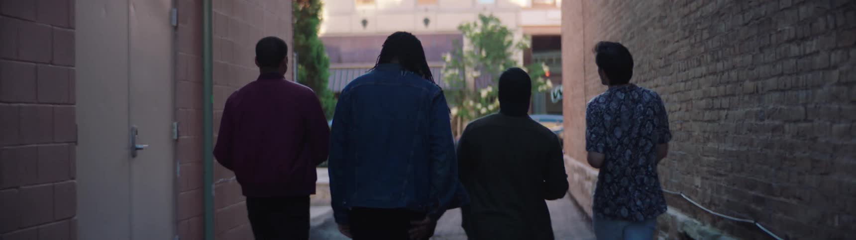 Group of friends walks down alley in city