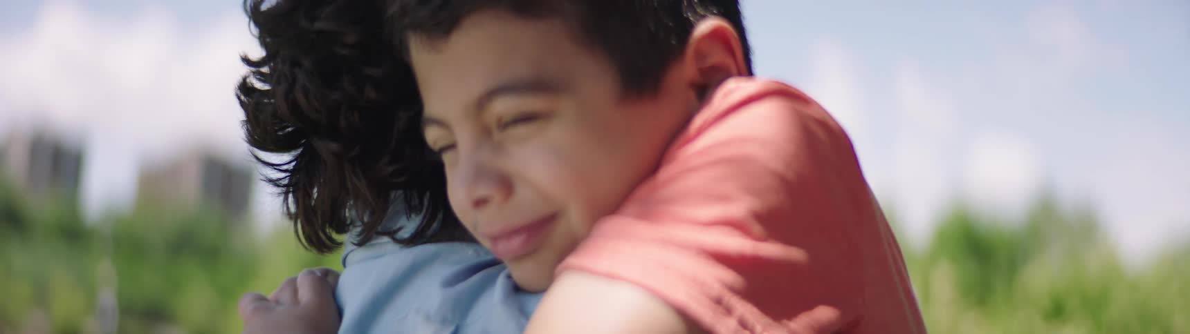 A father and son hug each other while outdoors