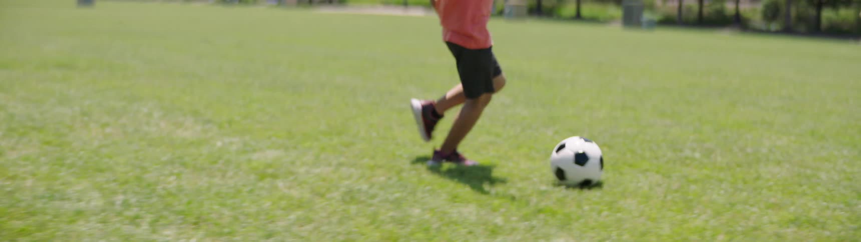 Father and son playing soccer in park