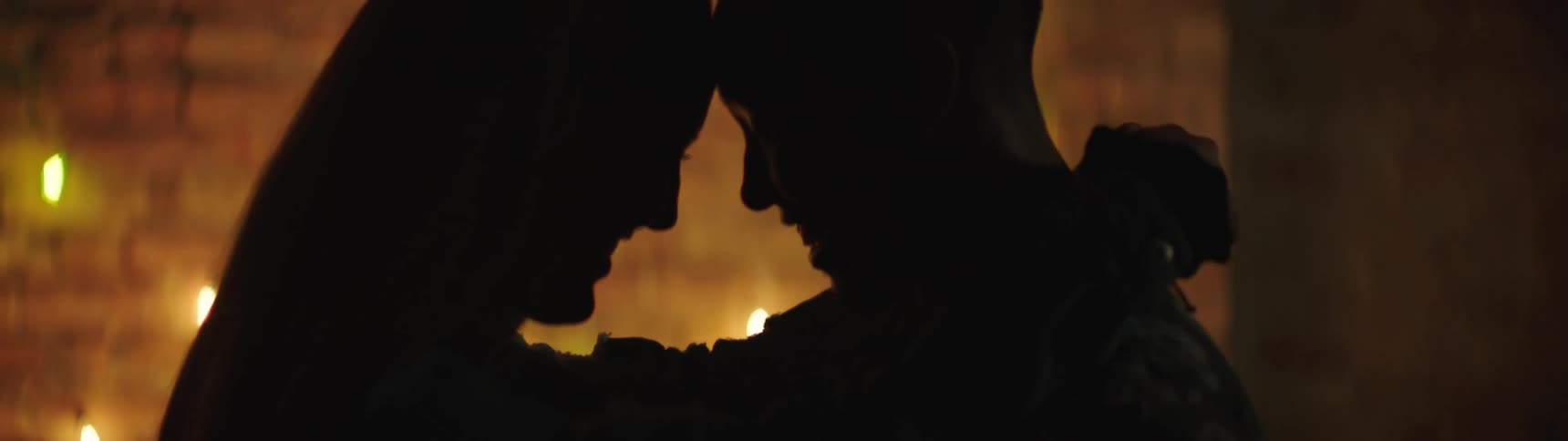 A man and woman put their heads together as they dance