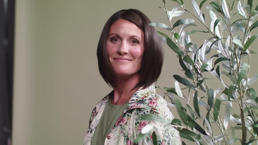 Woman standing next to plant for a photo shoot