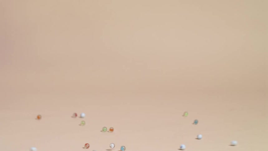 Person dumps marbles from gold dish