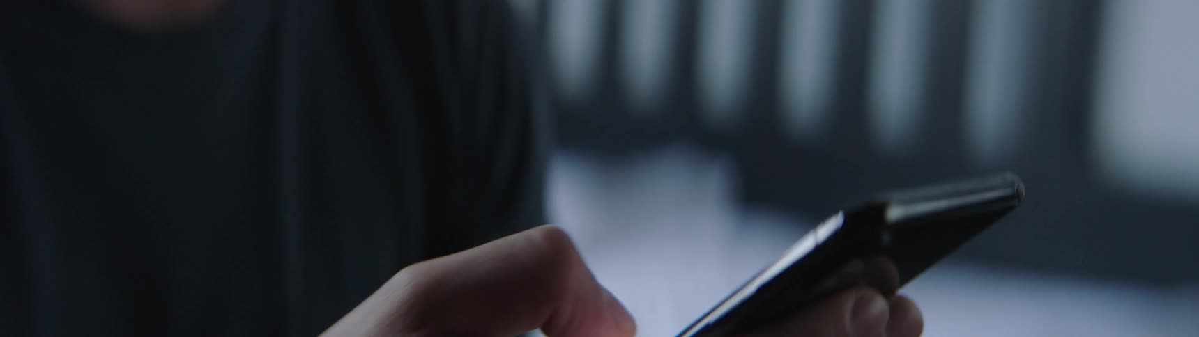 A white person vigorously scrolls on a smartphone with his thumb and fingers