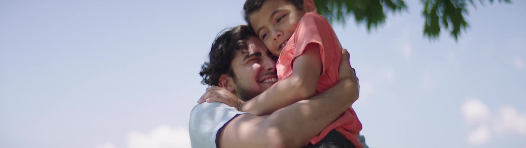 Father and son cuddle each other in the public park