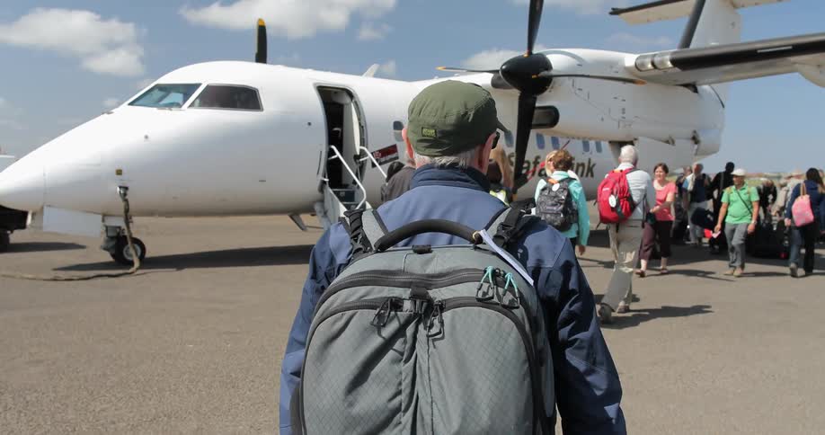 A group of people walk around a white plane