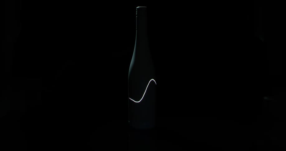 Light waves shine on a dark wine bottle