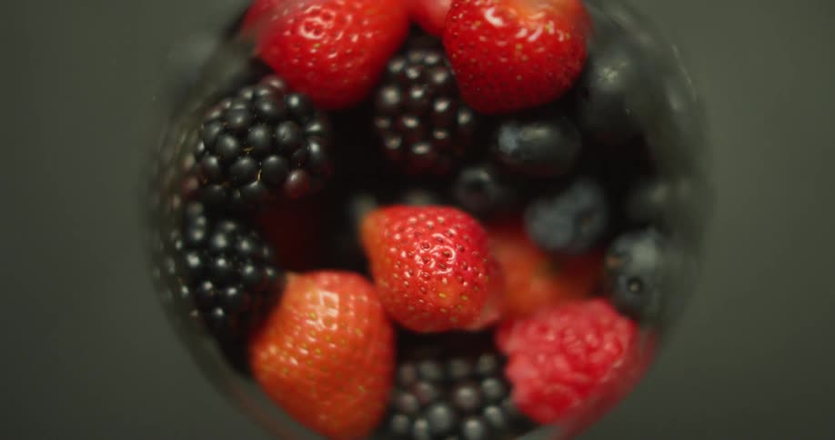 Strawberries blackberries and blueberries in a cup rotating