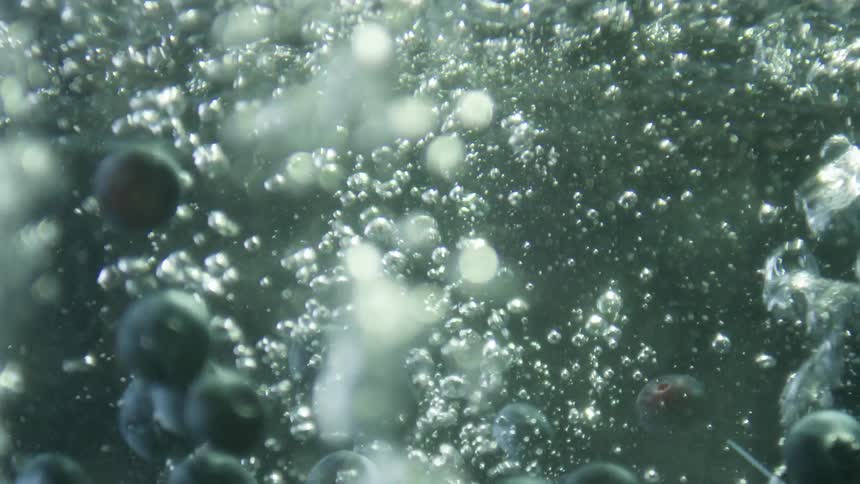 Blueberries are being dropped into the water