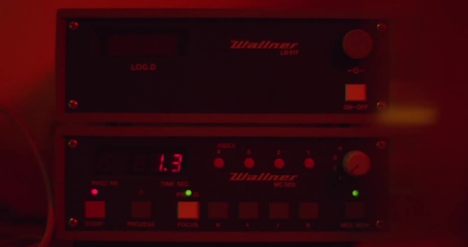 A finger pushes a button on a piece of equipment