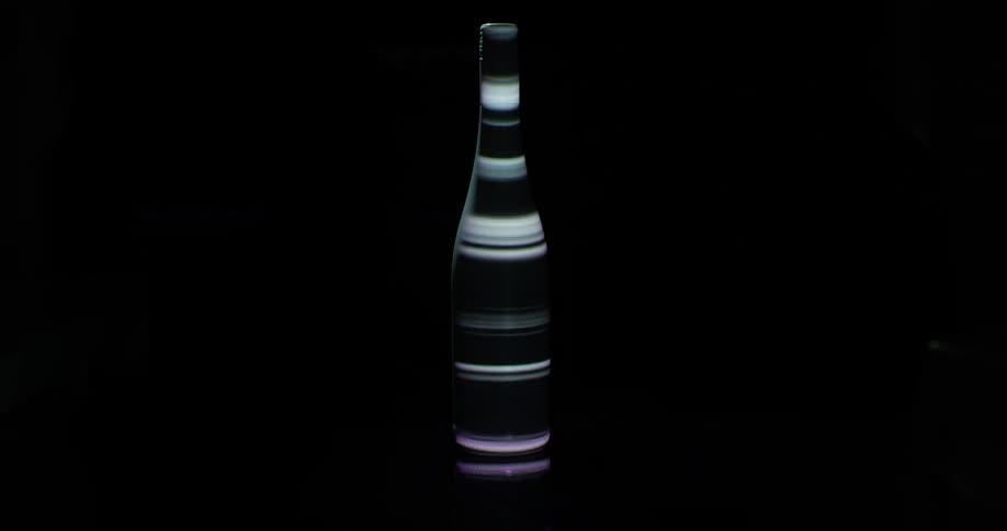 Glass bottle with abstract lights on a dark background