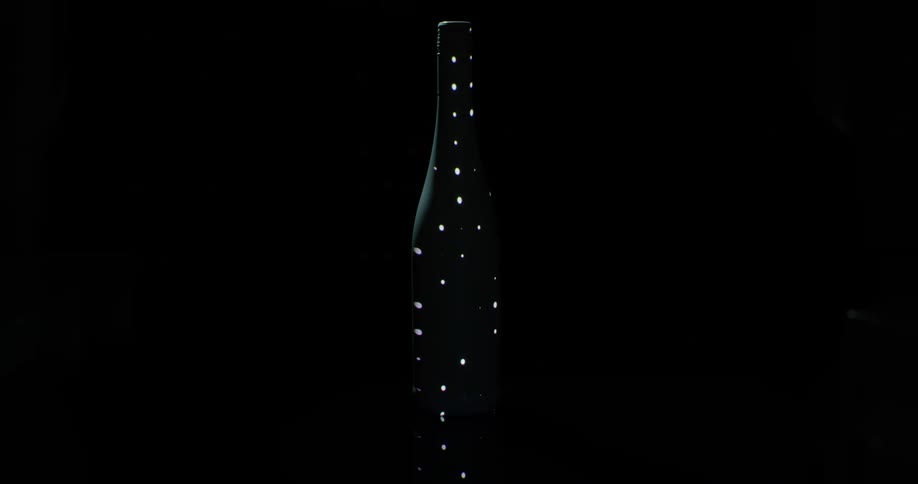Lights shine on a bottle in the dark