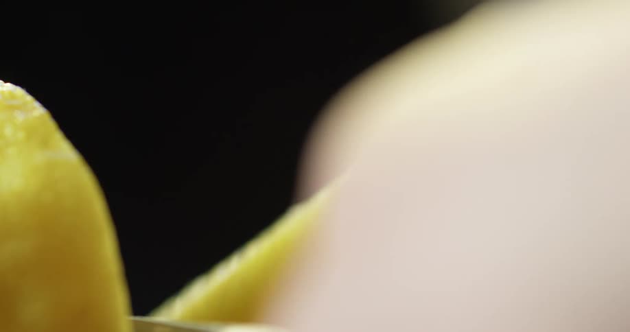 A person cuts a lemon in half