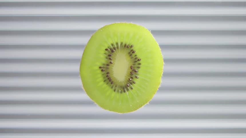 Half of a kiwi fruit with black seeds and green flesh