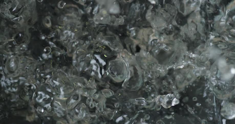 Fruit / Blueberrie drops into water creating bubbles that fizz out