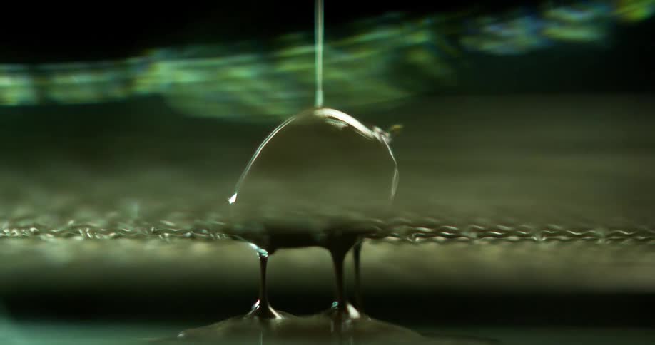 Chocolate is being poured on a strawberry