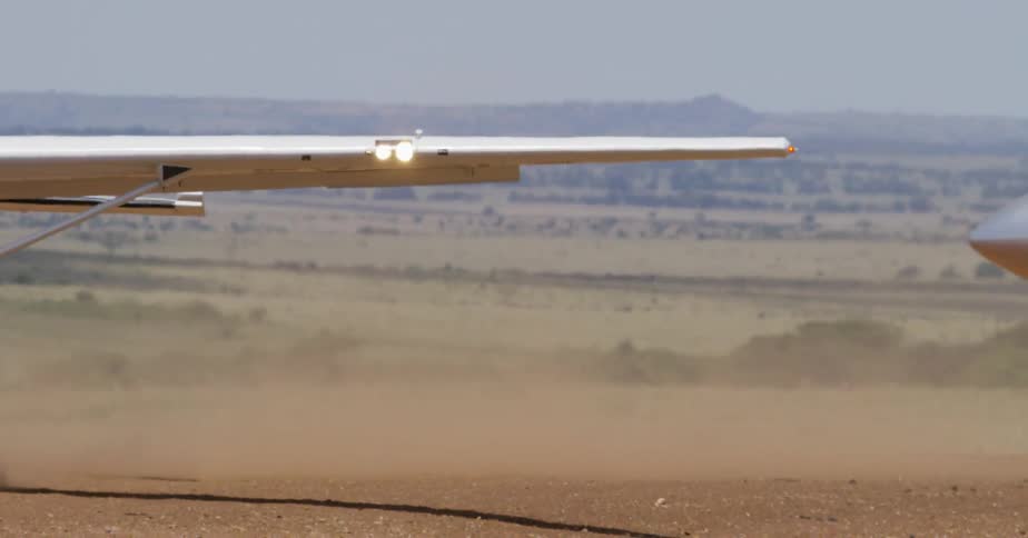 Small airplanes drive on a dirt field on a sunny day