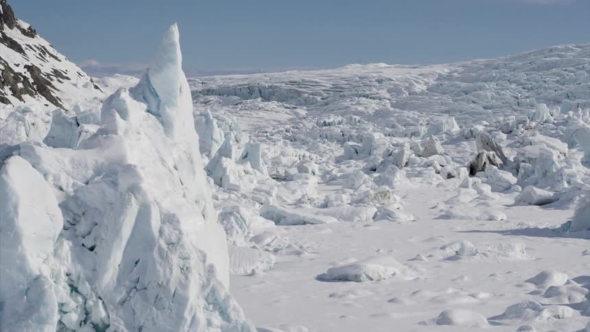 Snow and ice formations on rocky terrain on a bright sunny blue sky day
