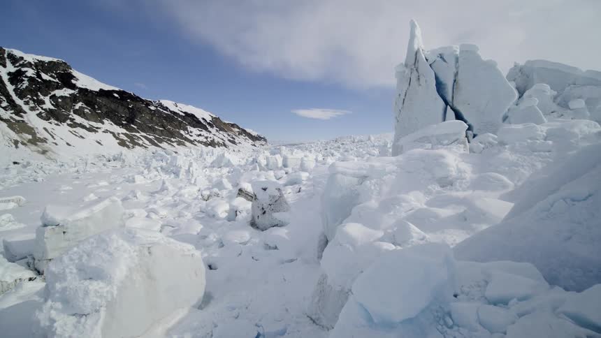 Huge chunks of broken ice litter the landscape in a mountain valley
