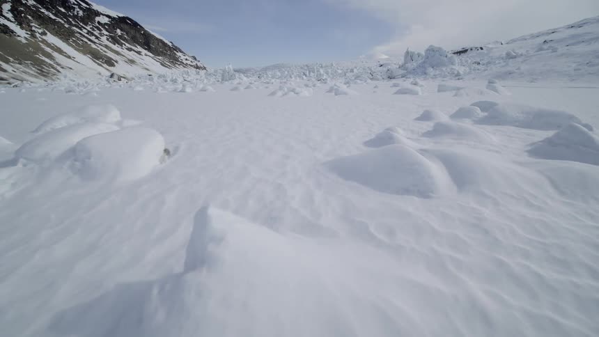 A valley near a mountain is covered in deep snow