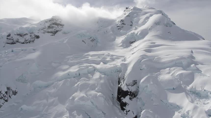 A mountain covered with snow with the sky in the background