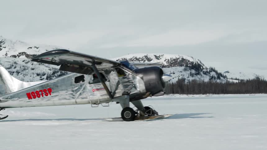 An airplane rolls across the snow during the winter
