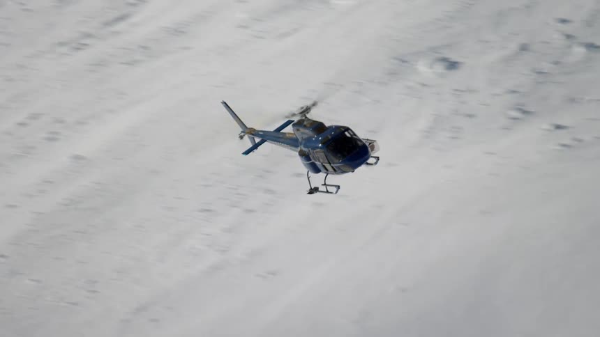 A helicopter flying over a mountain