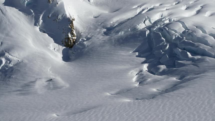 A helicopter landing in a vast snow covered arctic landscape