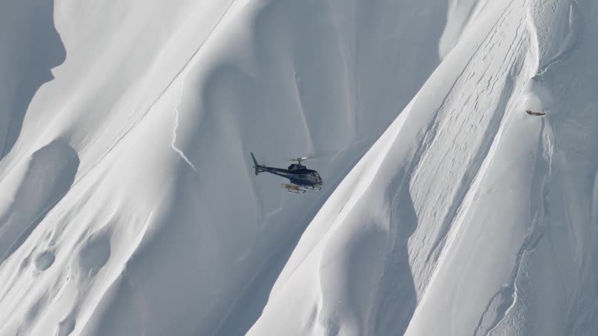A helicopter flying up the side of a mountain