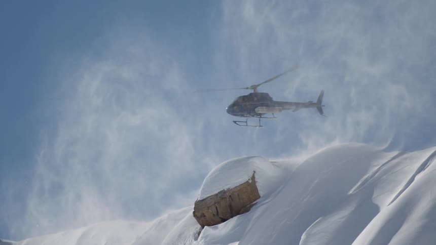 A helicopter taking off from a mountain top