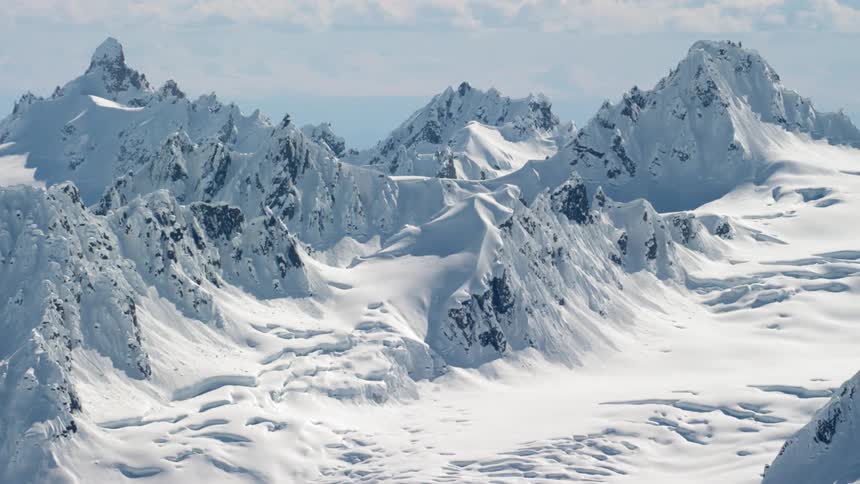 Mountain range peaks covered in snow at day
