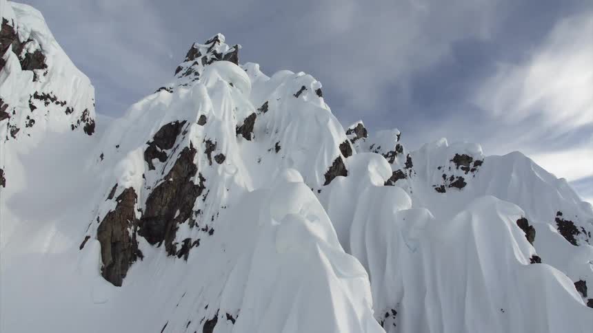 Tall wedge like snow dunes on the slopes of a mountain