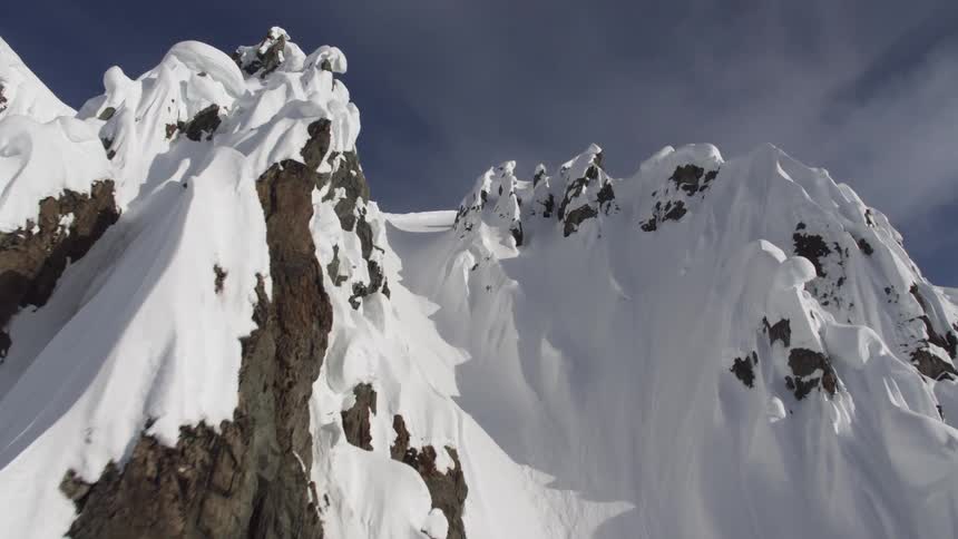 A mountain range is displayed with snow