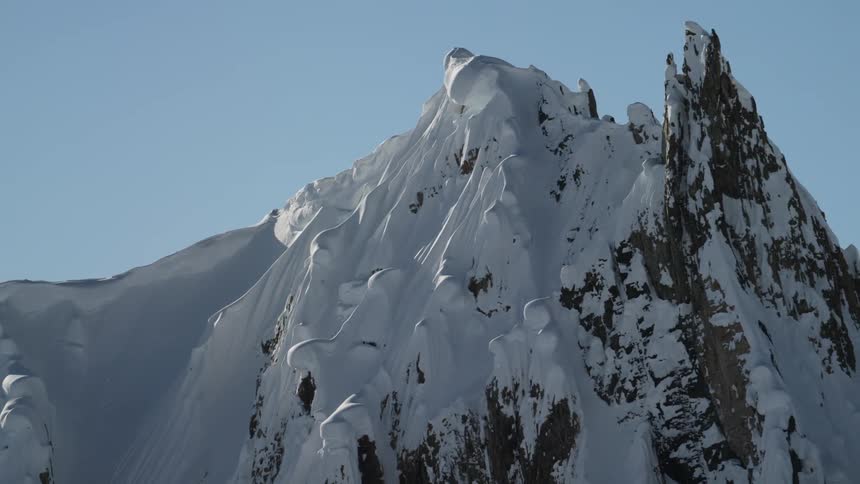 A snow covered mountain with the sky in the background