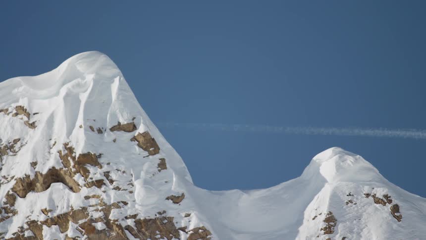 The plane flies over the mountains