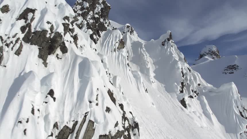 The side of mountains peak out under a thick layer of snow