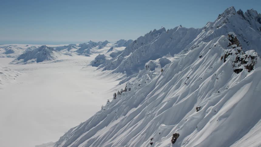 Snow is undisturbed on land between mountain ranges