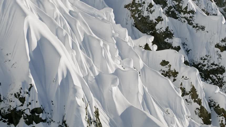 A steep mountain slope covered in deep snow