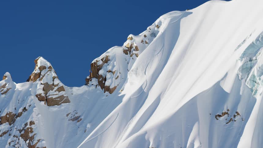 A snow covered mountain ridge with the sky in the background