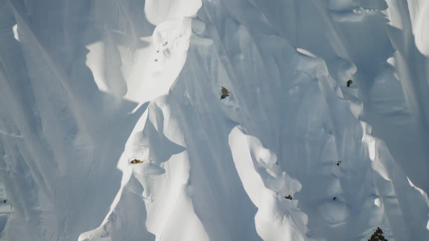 Two climbers stand on the peak of snow covered mountain