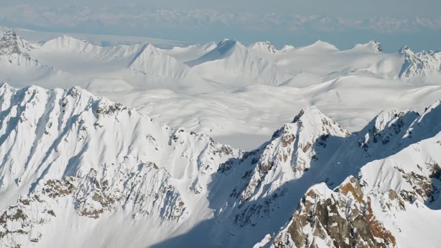 Snow blankets most of a large mountain range