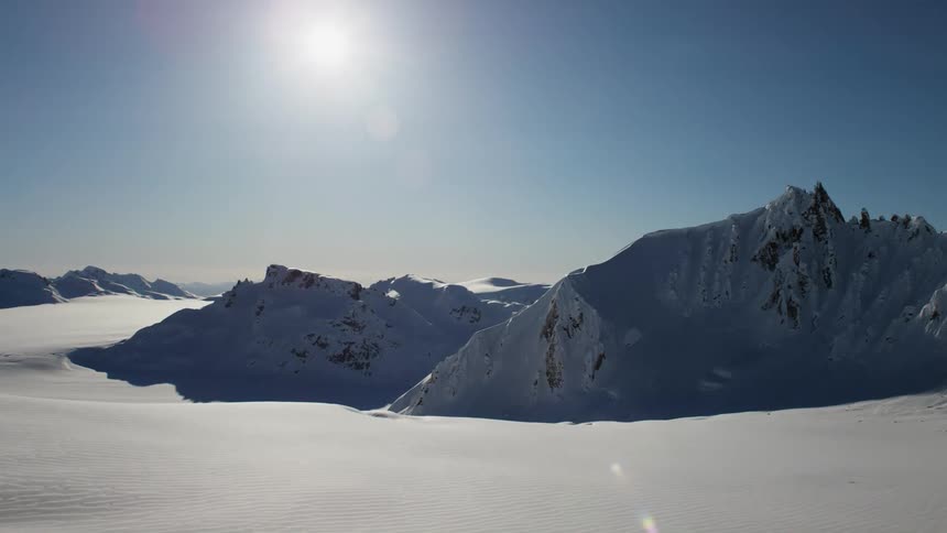 Sun shines over the snow covered plains near mountain range