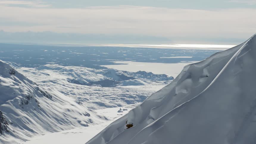 Camera in mountains zooms forward towards distant lake