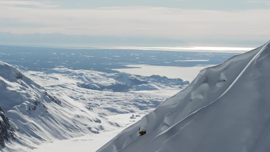 Snow covered mountains and valley with wide shot of horizon